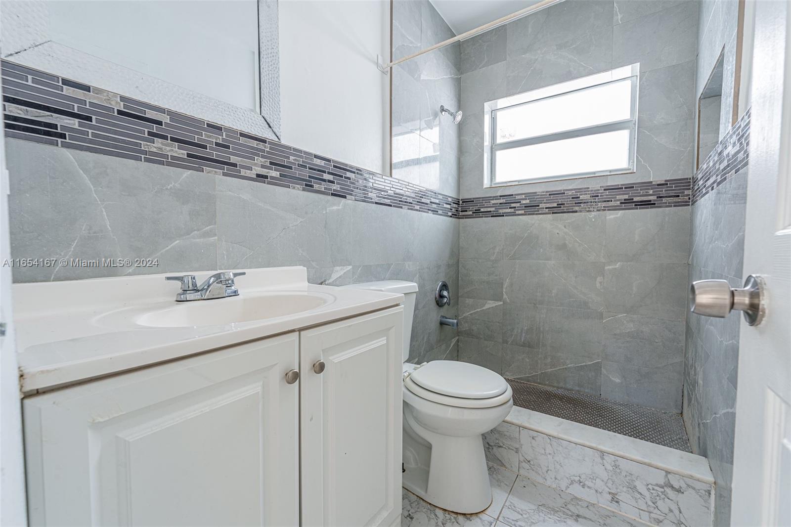 621 Southwest 15th Avenue, Unit 4 Miami, FL 33135 - Photo 9 of 22 a bathroom with a granite countertop sink a toilet and a shower