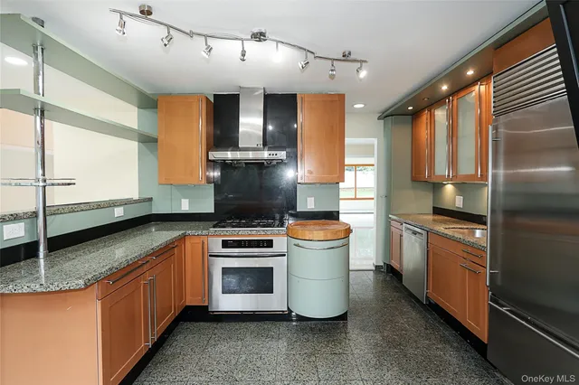 a kitchen with stainless steel appliances granite countertop a sink a stove and a refrigerator