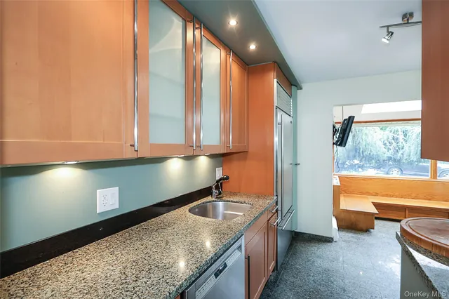 a kitchen with stainless steel appliances granite countertop a sink and a granite counter tops with a large window