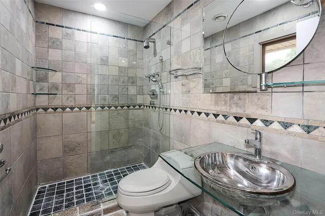 a bathroom with a granite countertop sink a toilet and mirror
