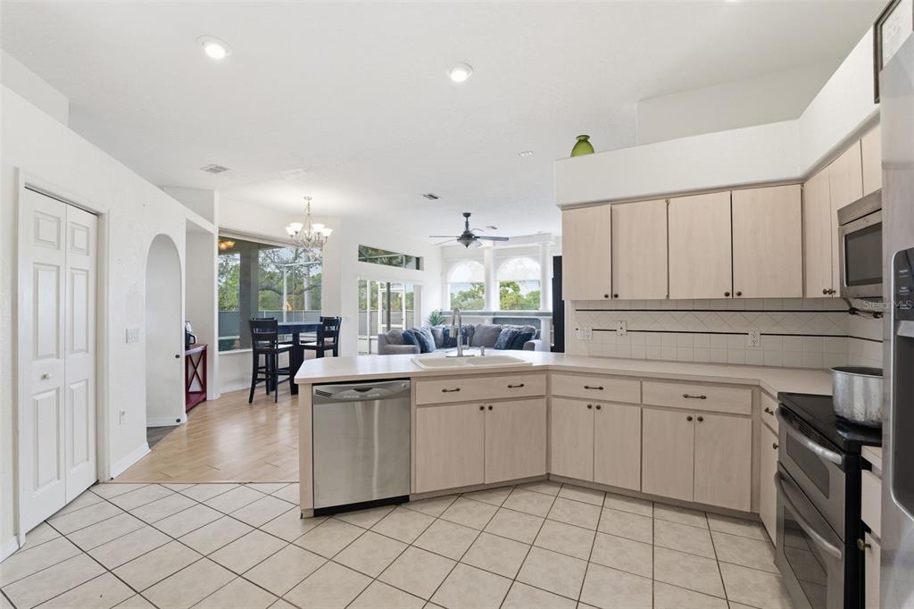 13403 Bolton Court Spring Hill, FL 34609 - Photo 21 of 36 a kitchen with white cabinets appliances and a window