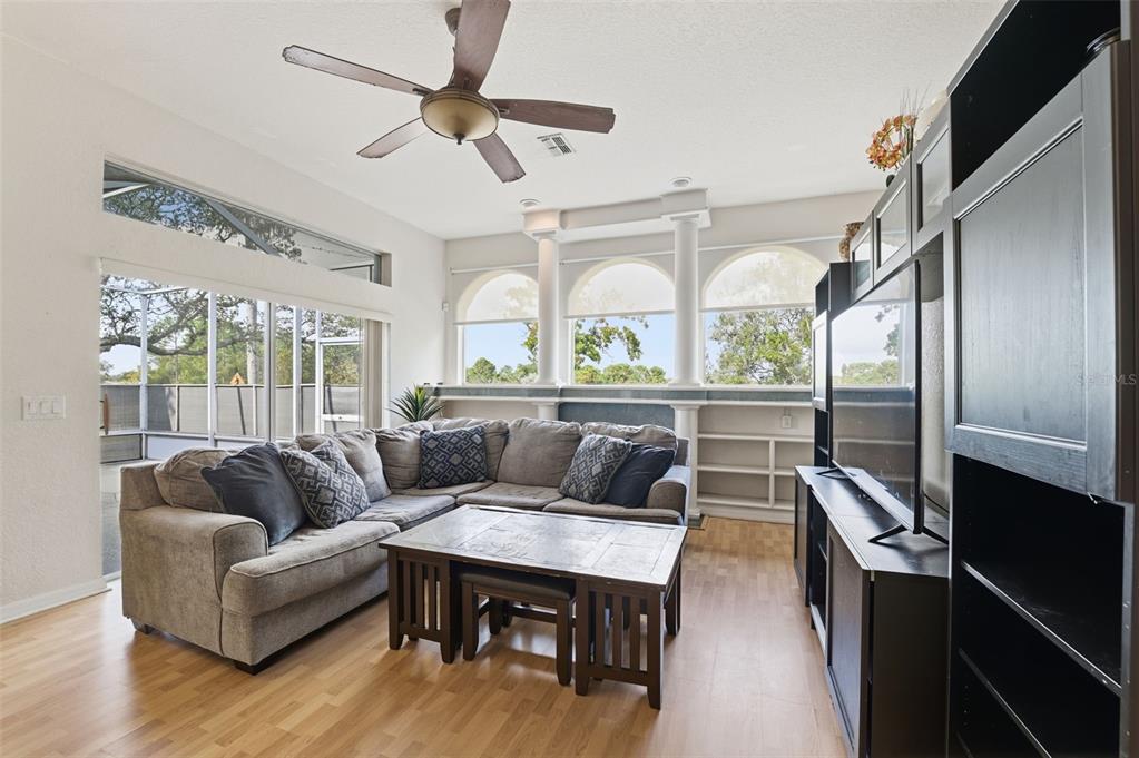 13403 Bolton Court Spring Hill, FL 34609 - Photo 25 of 36 a living room with furniture a large window and wooden floors