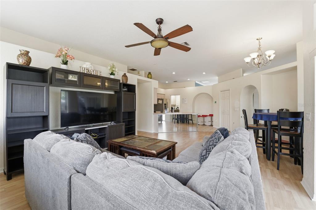 13403 Bolton Court Spring Hill, FL 34609 - Photo 27 of 36 a living room with furniture and a flat screen tv with kitchen view