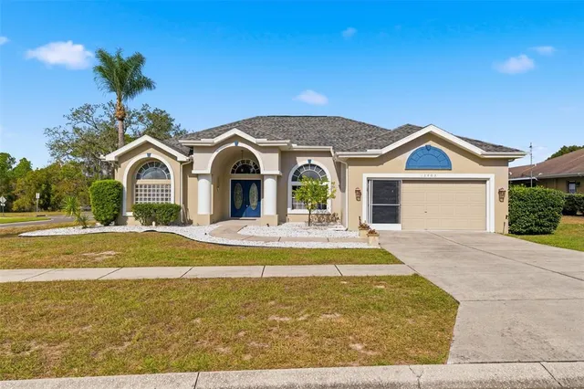 a view of house with garden and tall tress