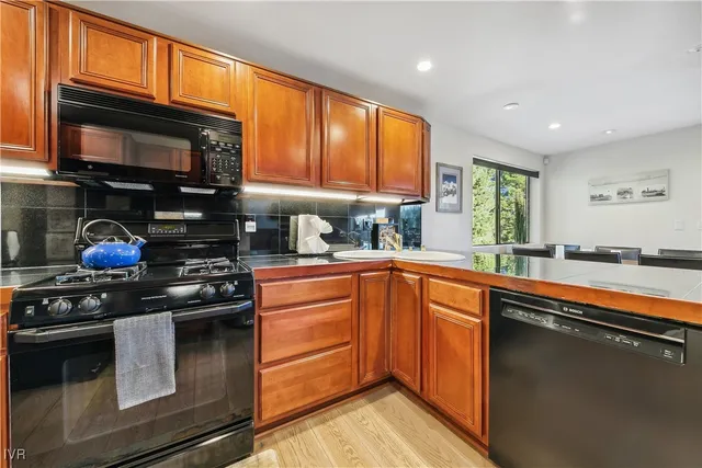 a kitchen with stainless steel appliances granite countertop a stove sink microwave and cabinets