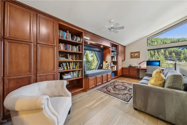 a living room with furniture a bookshelf and a large window