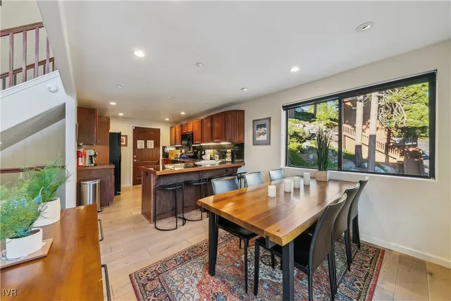 a living room with stainless steel appliances granite countertop furniture wooden floor dining table and a large window