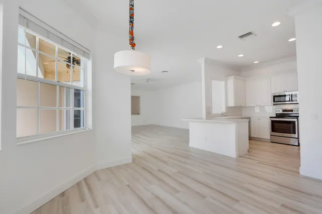 a view of kitchen with wooden floor and electronic appliances