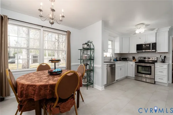 a kitchen with granite countertop a stove dining table and chairs