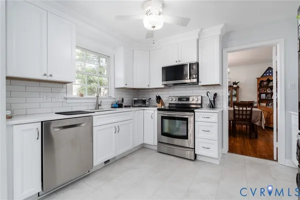 a kitchen with white cabinets and appliances