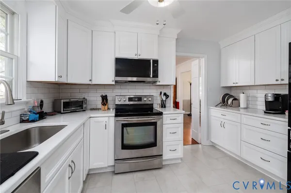 a kitchen with white cabinets and stainless steel appliances