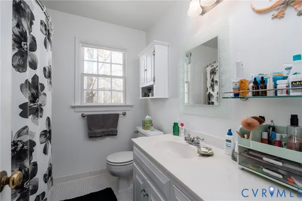 a bathroom with a sink a toilet and a window