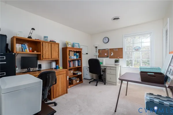 a view of a workspace with furniture and a window