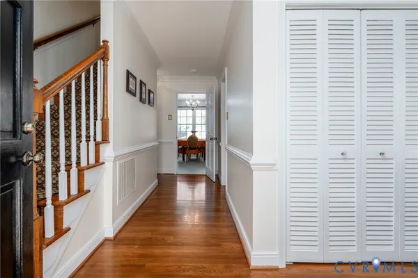 a view of a hallway with wooden floor and staircase