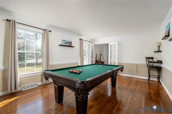 a room with furniture pool table and windows