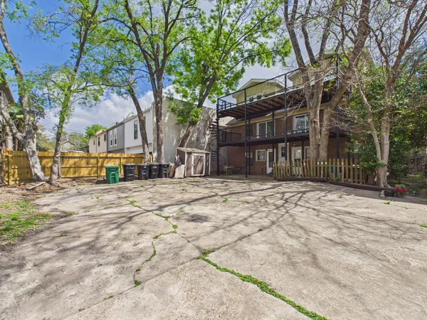 a view of a yard in front of a house with a large tree