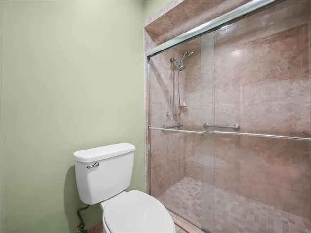 a white toilet sitting next to a shower