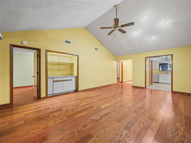 a view of a livingroom with wooden floor and a ceiling fan