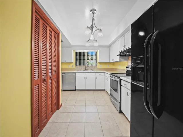 a kitchen with a sink stainless steel appliances furniture and a window