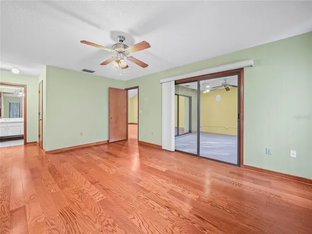 an empty room with fan and windows