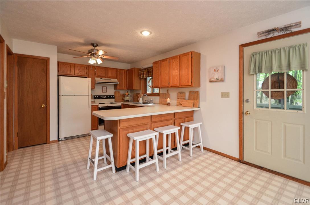 208 Regent Street Bushkill, PA 18324 - Photo 12 of 37 a kitchen with kitchen island a stove a table and chairs in it