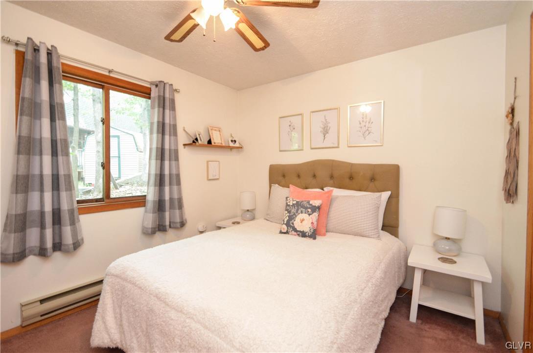 208 Regent Street Bushkill, PA 18324 - Photo 17 of 37 a bedroom with a large bed and a chandelier