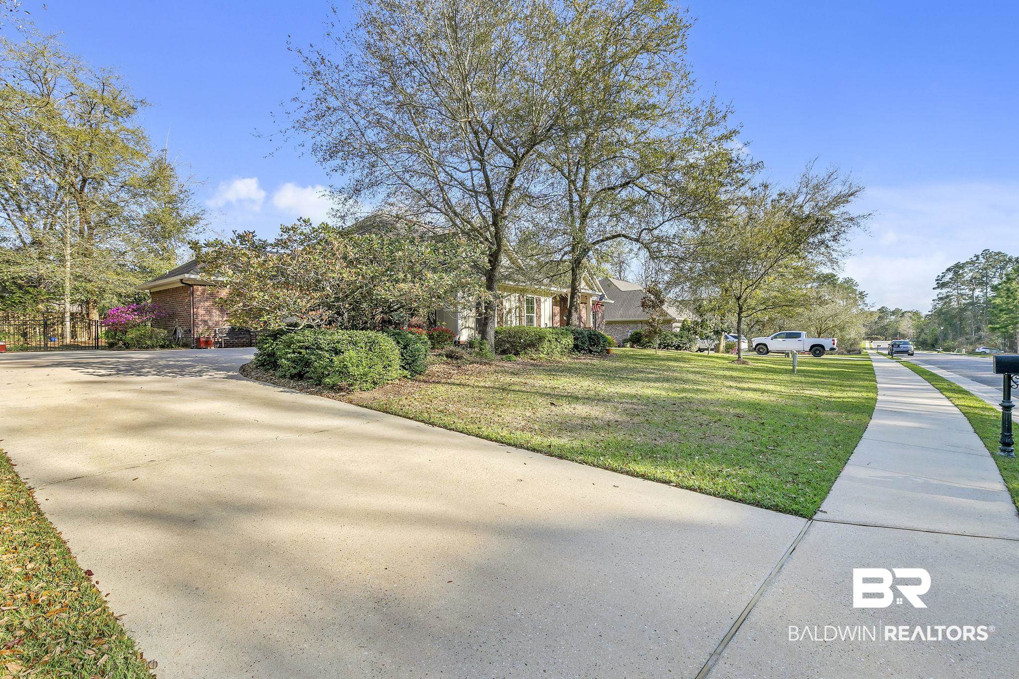 20105 Bunker Loop Fairhope, AL 36532 - Photo 57 of 65 Exterior space featuring driveway and a yard