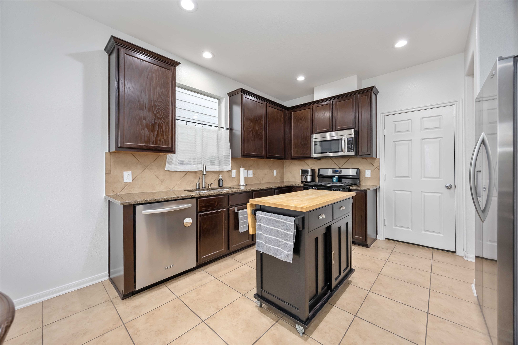 2019 Falcon Reach Drive Houston, TX 77080 - Photo 12 of 30 a kitchen with stainless steel appliances granite countertop a stove a sink and a refrigerator with wooden cabinets