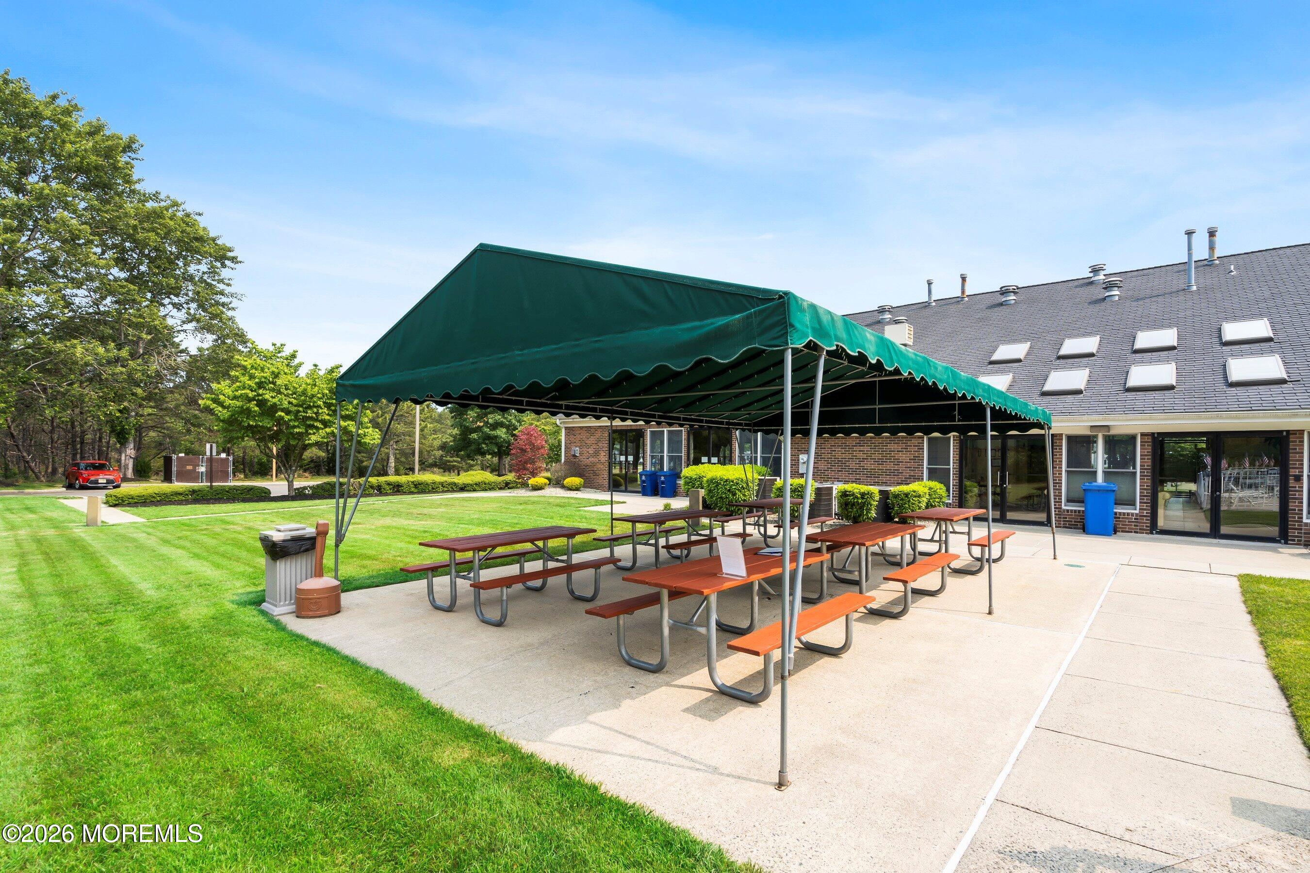 536 Momosa Way Whiting, NJ 08759 - Photo 49 of 54 a patio with a table and chairs under an umbrella