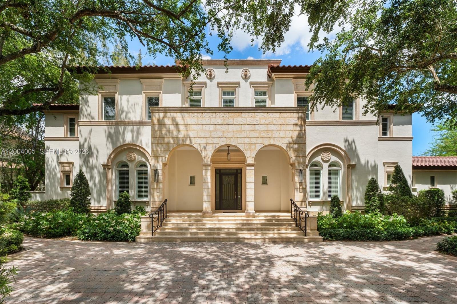 255 Cocoplum Road Coral Gables, FL 33143 - Photo 2 of 29 a front view of a house with a garden