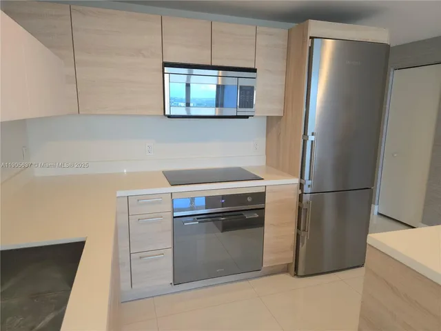 a kitchen with stainless steel appliances a refrigerator sink and microwave
