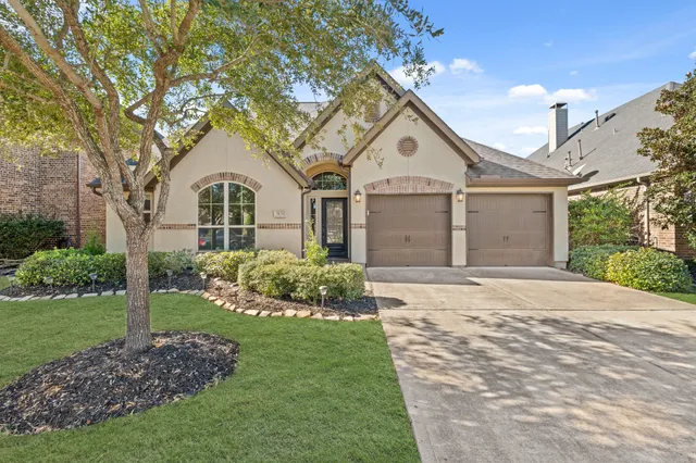 a front view of a house with a garden and yard