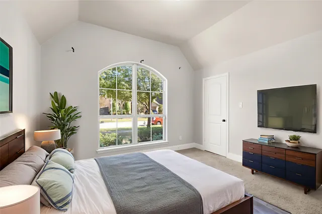 a bedroom with a bed and a flat screen tv