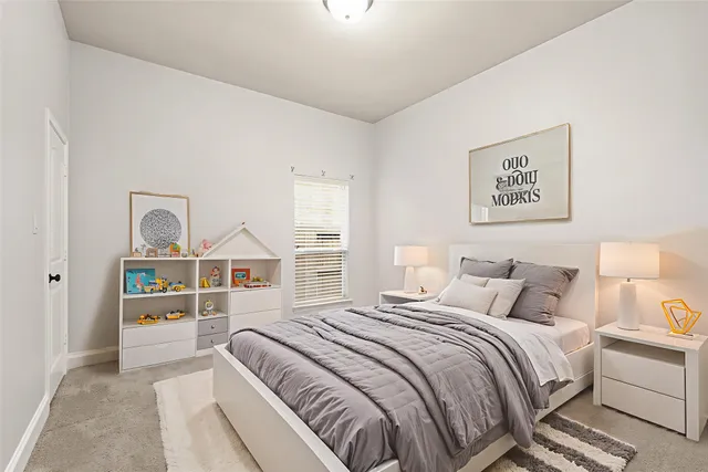 a bedroom with a bed next to a window with the view of bedroom