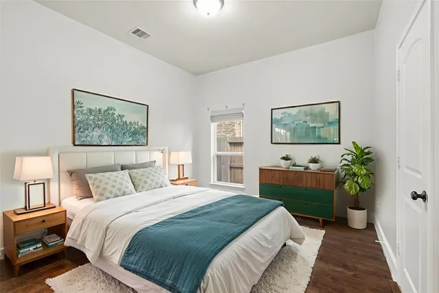 a bedroom with a bed and a potted plant