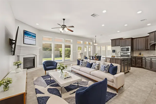 a living room with furniture fireplace and kitchen view