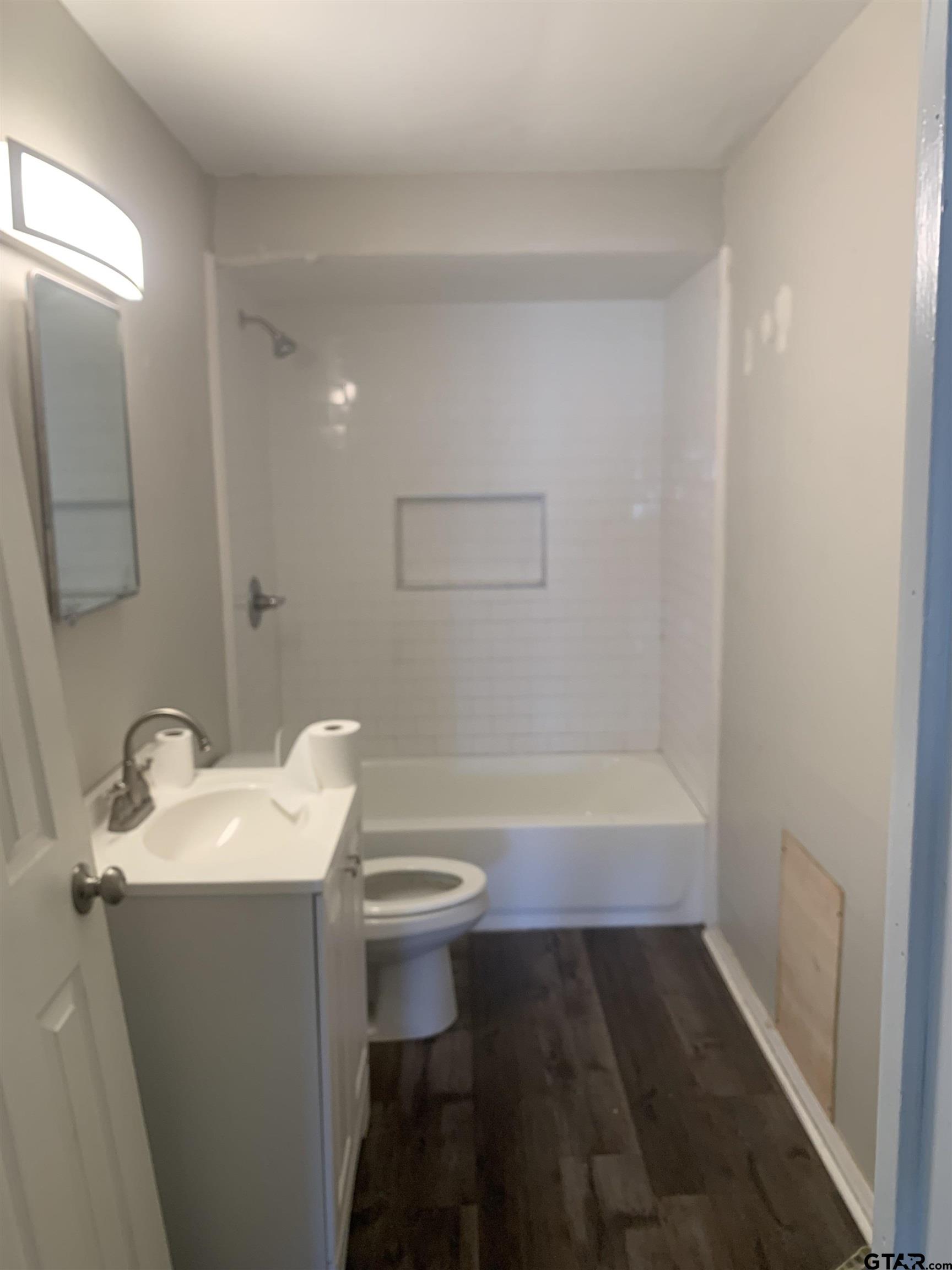 2722 Bunche Street Tyler, TX 75701 - Photo 6 of 6 a bathroom with a tub sink and mirror
