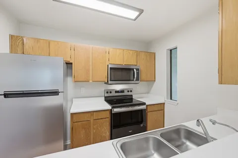 a kitchen with stainless steel appliances granite countertop a stove microwave and refrigerator
