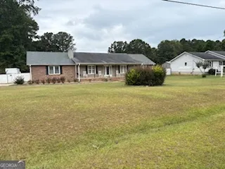 a front view of a house with a garden and yard