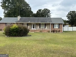 a front view of a house with a garden and plants