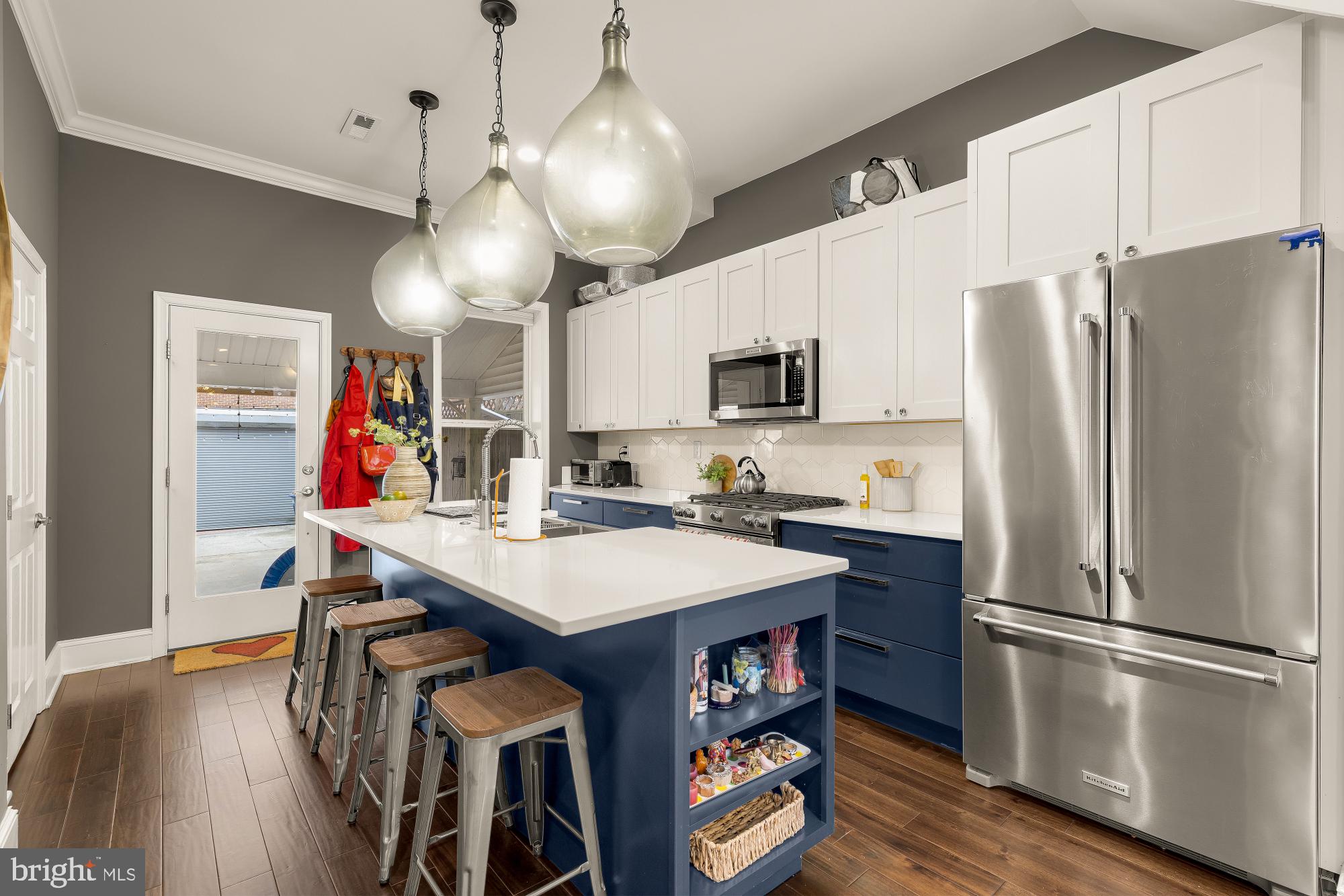 421 10th Street Northeast Washington, DC 20002 - Photo 15 of 61 a kitchen with stainless steel appliances a refrigerator a stove a microwave oven a dining table and chairs with wooden floor