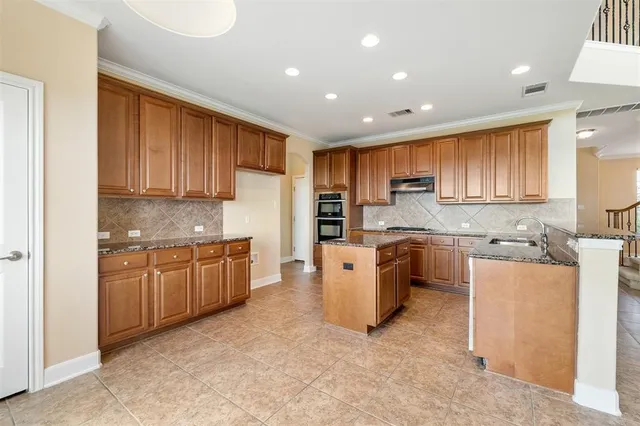 a large kitchen with stainless steel appliances granite countertop a stove a sink and a refrigerator