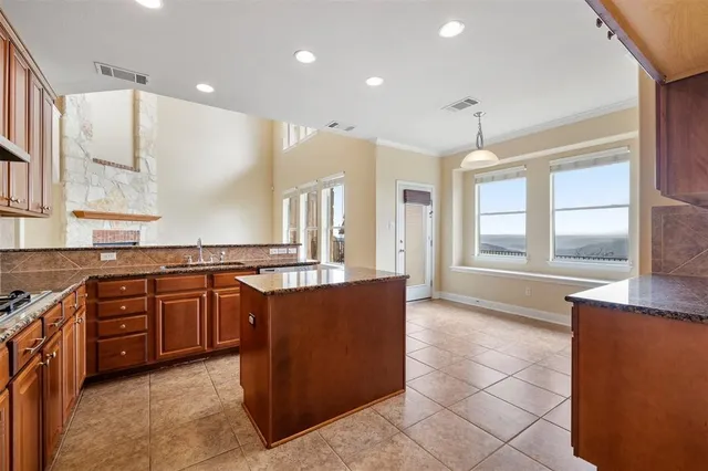 a kitchen with stainless steel appliances granite countertop a sink stove and cabinets