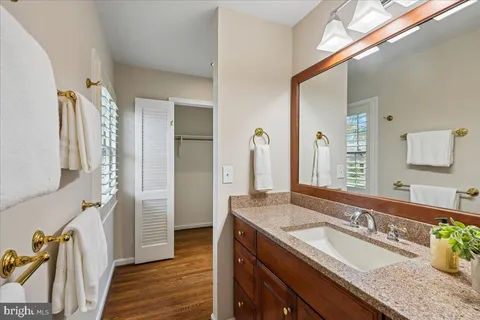 a bathroom with a granite countertop double vanity sink and a mirror