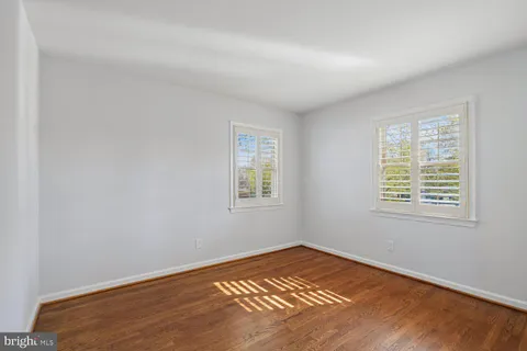 a view of a room with wooden floor and a window