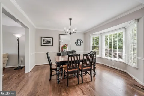 a kitchen that has a stove a table and chairs in it