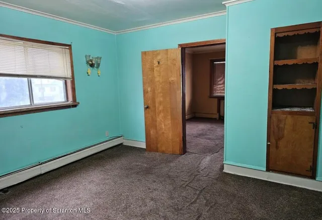 an empty room with closet and windows
