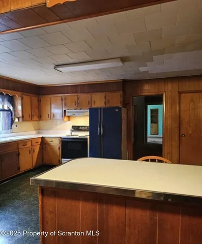 a kitchen with a table chairs sink and cabinets