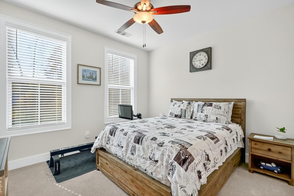 304 Liberty Way Woodstock, GA 30188 - Photo 23 of 42 a bedroom with a bed and a chandelier