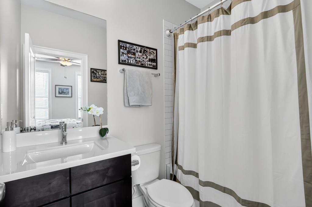304 Liberty Way Woodstock, GA 30188 - Photo 24 of 42 a bathroom with a sink a toilet and shower curtain